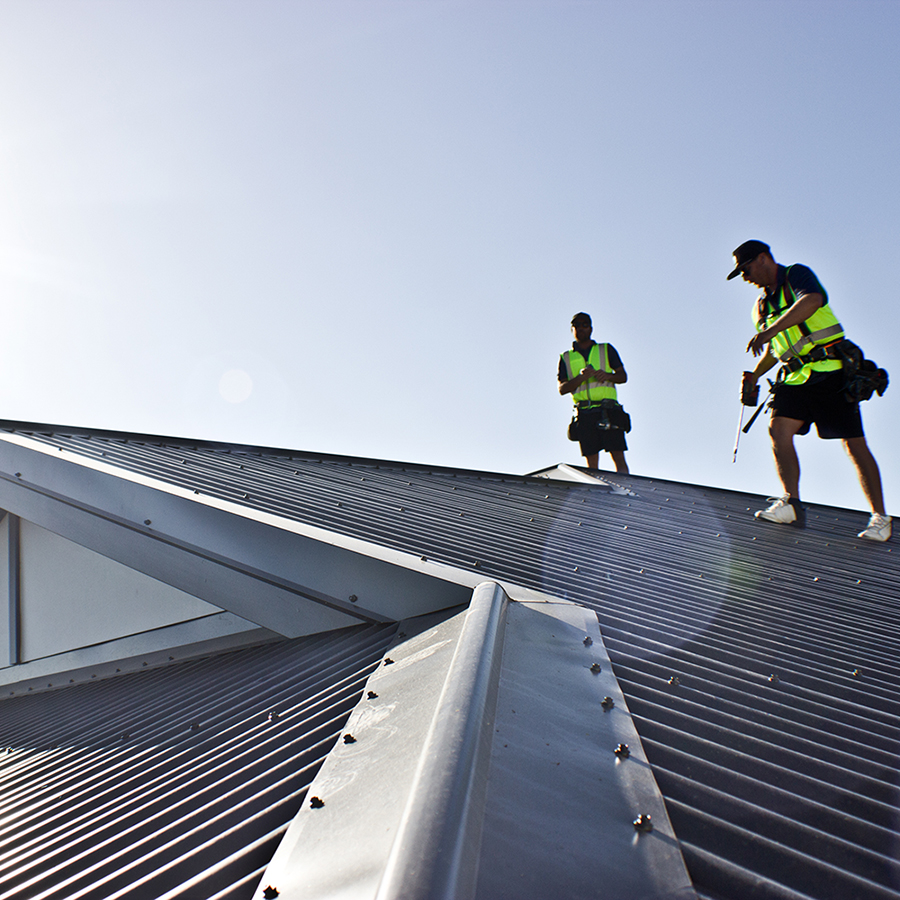two male roofers putting the finishing touches on a metal roof in Perth